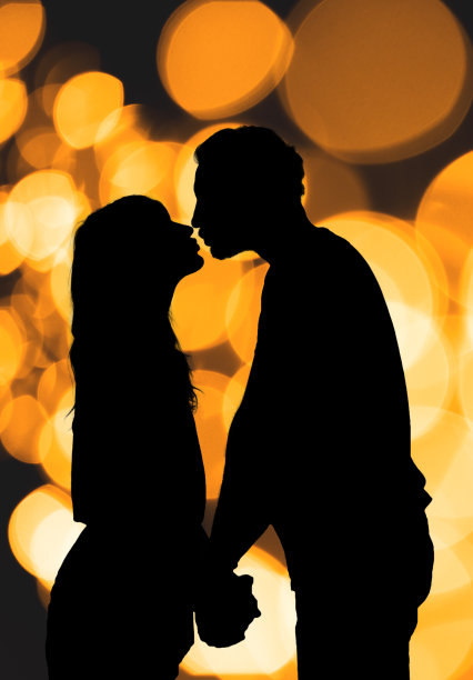 一对夫妇的剪影与非聚焦/散景灯。图片下载