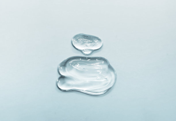 在蓝色背景上用凝胶和水制成的香水瓶图片下载