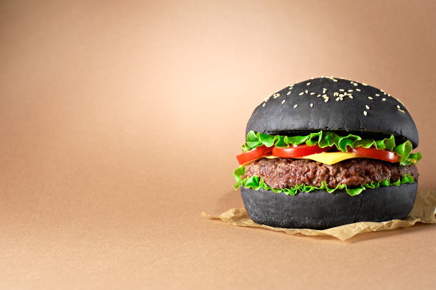 黑色汉堡与牛肉和奶酪孤立的纸张背景。图片下载