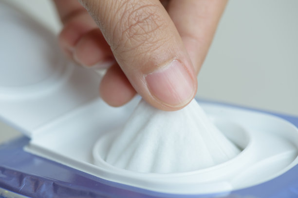 特写女人手拿湿纸巾从包装。图片下载