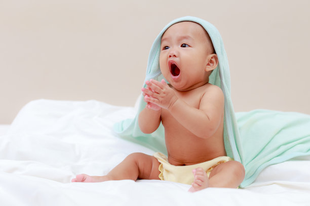 亚洲小婴儿穿着蓝色的头巾，在家里的卧室里图片下载