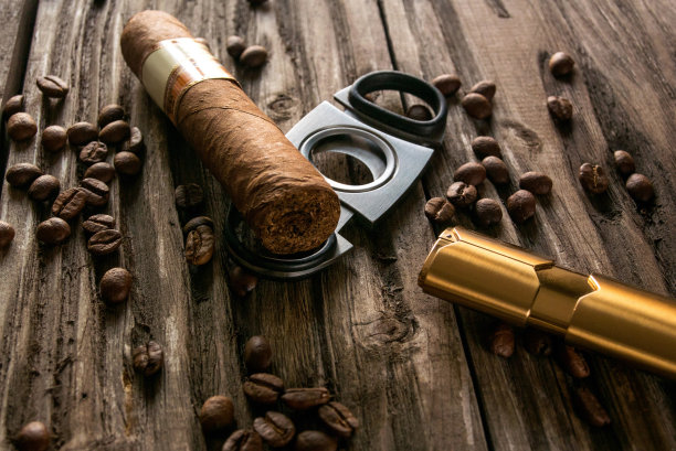 雪茄的特写与咖啡豆和较轻的粗糙的木头图片下载