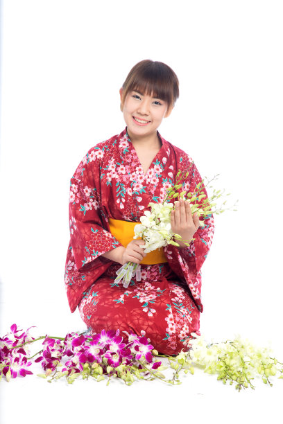 迷人的亚洲女人穿着和服与兰花花在白色的背景。图片下载