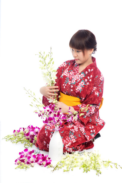 迷人的亚洲女人穿着和服与兰花花在白色的背景。图片下载