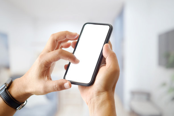 一个不明身份的男子在办公室使用智能手机的特写镜头。空白屏幕的图形显示蒙太奇图片下载