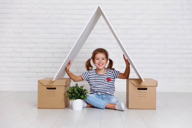 移动和住房的概念。快乐的小女孩拿着盒子图片下载