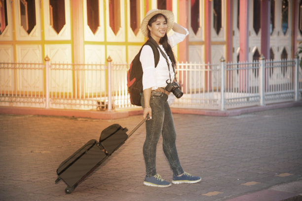 漂亮的亚洲女性与行李和等待在泰国火车站的火车。图片下载