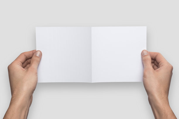 模型的正方形空空白弯曲在一半白色明信片持有的人在他的手。孤立在灰色背景上图片下载