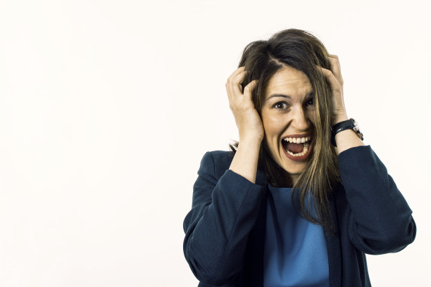 尖叫的女人疯狂地扯她的头发。应力的概念。图片下载