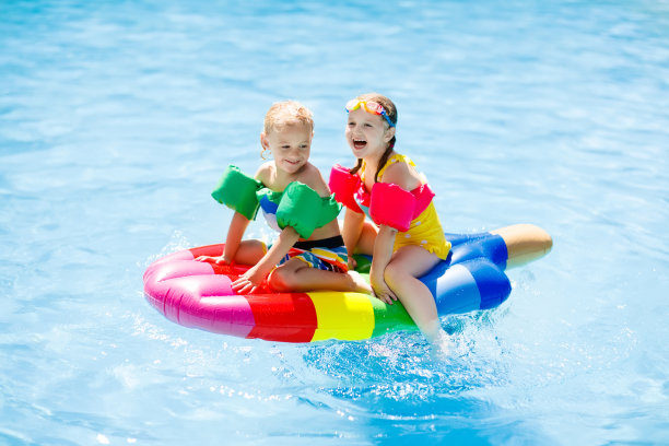 孩子们在游泳池里的充气浮子上。图片下载