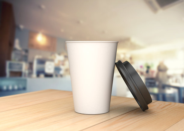 咖啡杯放在背景模糊的木桌上。图片下载