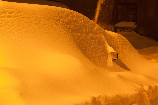 夜幕降临后，雪堆在汽车上图片下载