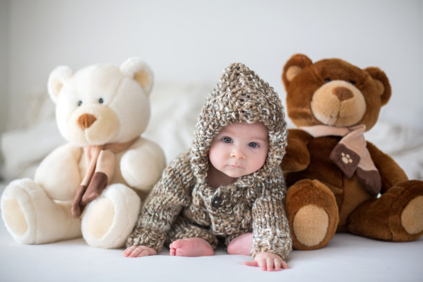 小男孩在家里玩着柔软的泰迪熊玩具，躺着图片下载