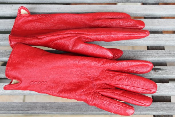 桌子上用皮革做的红色手套图片下载