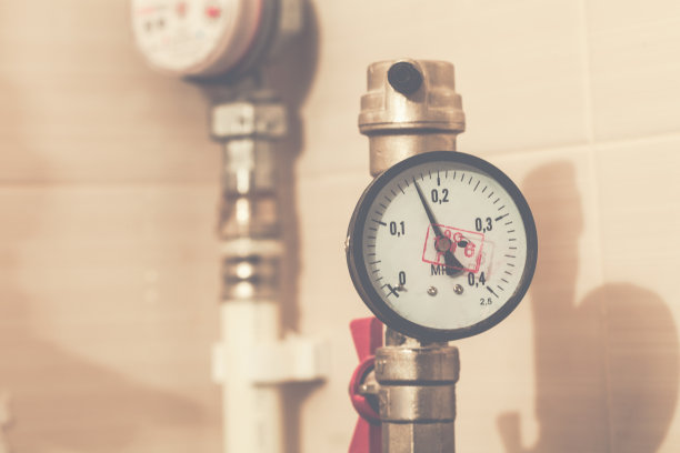 管道塑料水管上带有红色水龙头的中心管道压力计。图片与色调效果。图片下载