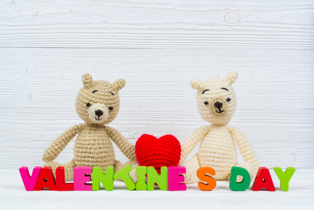甜蜜的夫妇泰迪熊娃娃在爱与情人节文字和红色编织心在白色木制背景和复制空间添加文字和图片，爱和情人节的概念。图片下载