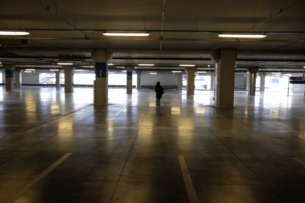 一个孤独的女人在空荡荡的商场停车场图片下载