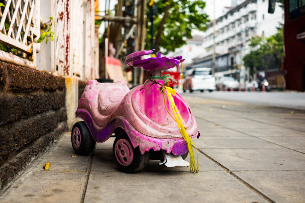 人行道上给孩子的旧玩具车。图片下载