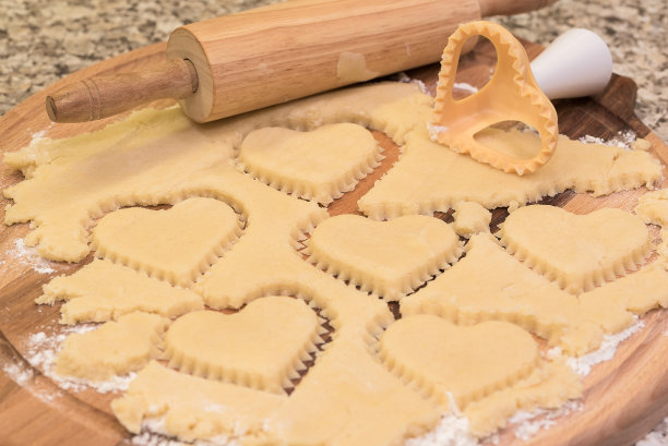 生面团上的心形饼干切割机。特写镜头。图片下载