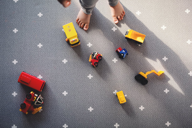 婴儿正在看地板上的汽车玩具。一个男孩独自在玩图片下载