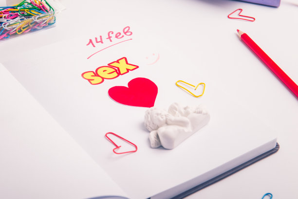 工作场所的个人记事本上有红心、性字和天使小雕像。情人节计划概念。有选择性的重点。副本的空间。图片下载