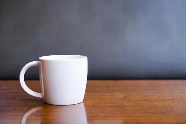 木桌上的一个白咖啡杯图片下载