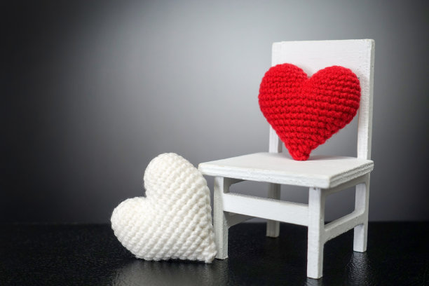 红色的心在白色的椅子和白色的心与黑色的背景-情人节概念图片下载