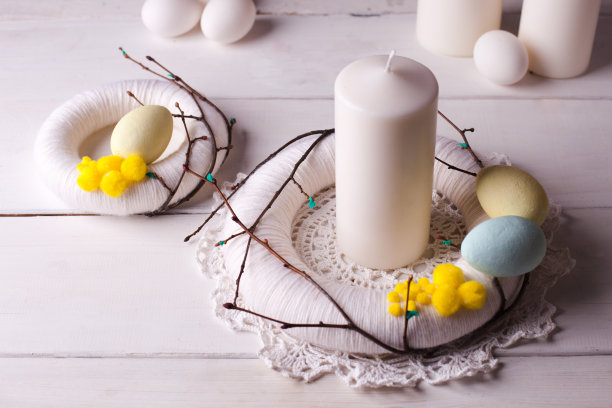 复活节装饰家居-灯装饰，花环，蜡烛和巢与白色的复活节彩蛋在白色的木制背景图片下载