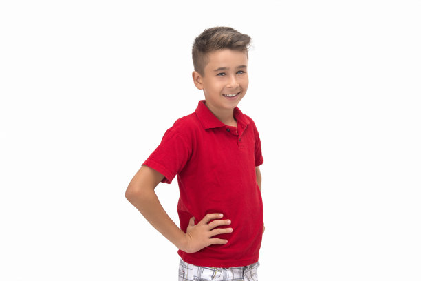 在白色背景下，微笑的孩子看着相机在臀部的位置图片下载