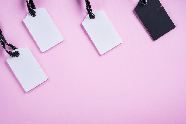 空的白色和黑色标签在一排粉红色的背景。前视图。模拟样品。空白的价格标签。设计购物标签模板，折扣，销售。销售标签。图片下载