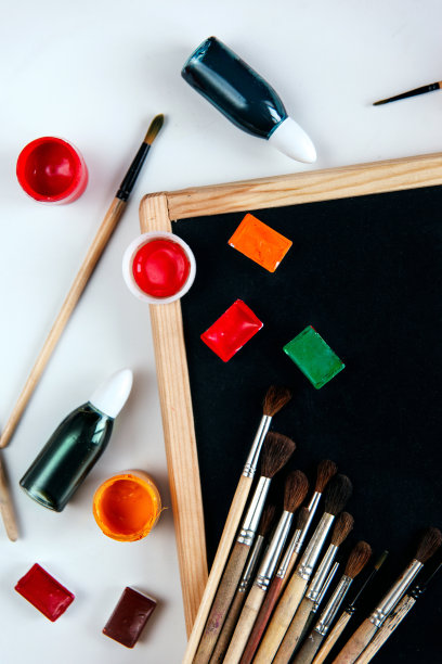 在一个空的黑色黑板上，放着绘画用具、颜料和画笔。创意与绘画的概念。使用拷贝空间的开销静物。图片下载