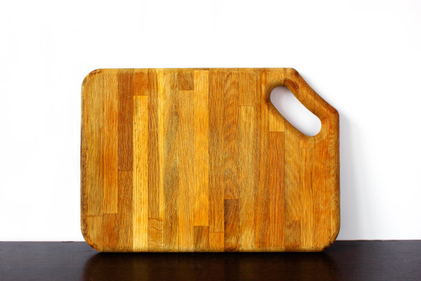木质砧板孤立地放在厨房的桌子上，白色的背景。图片下载