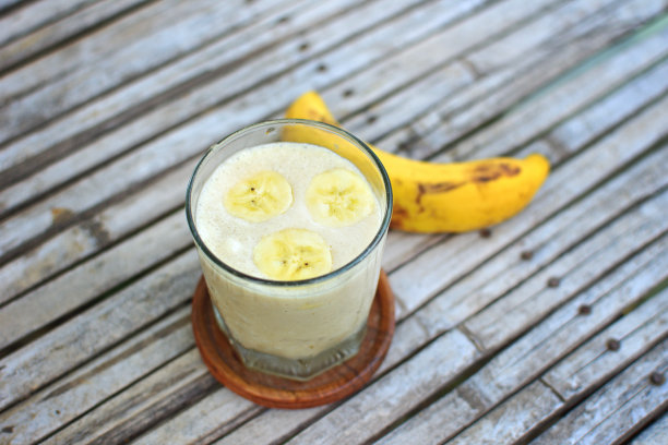 新鲜制作的香蕉奶昔在复古的木制背景图片下载