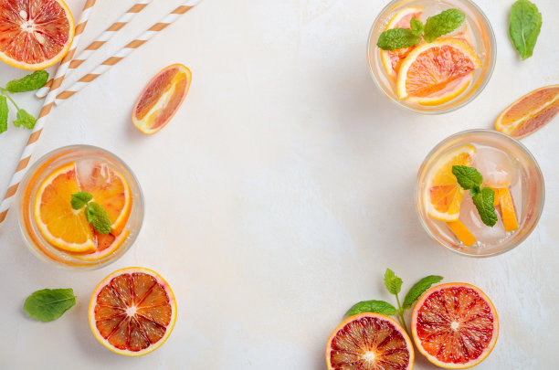 在白色的混凝土背景下，配以血橙片的冷饮。素材图片
