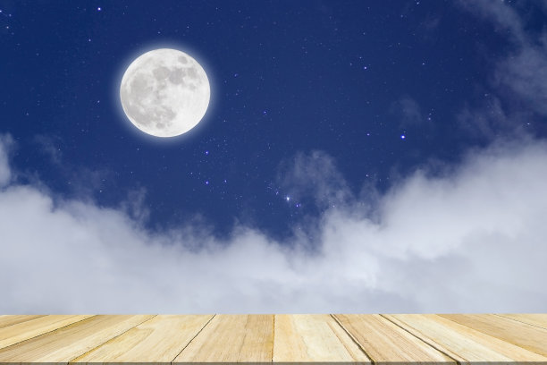 浪漫的夜晚。满月在云景与木材背景。图片下载