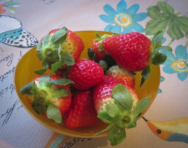 把草莓放在一个黄色的小碗里。图片下载