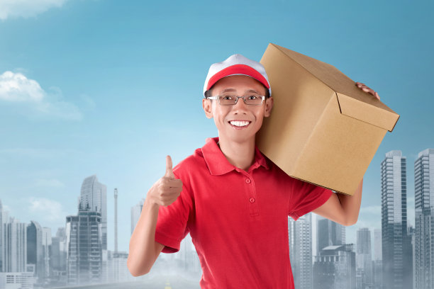 快乐的亚洲快递员扛着纸箱在肩上图片下载