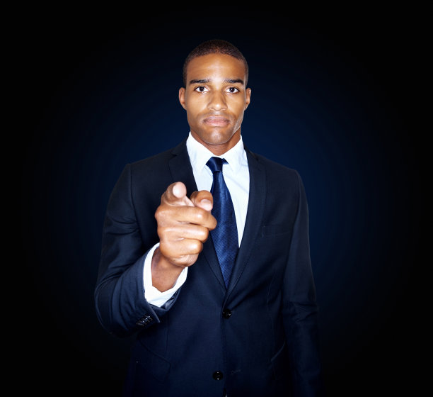 英俊的商人在黑色背景下指着你图片下载