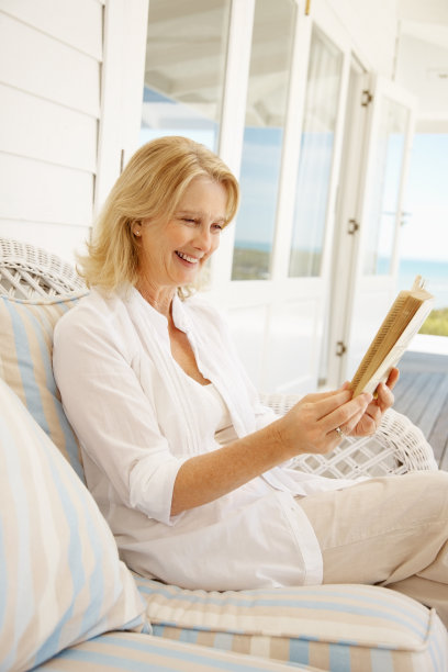 快乐成熟的女人在门廊边看小说图片下载