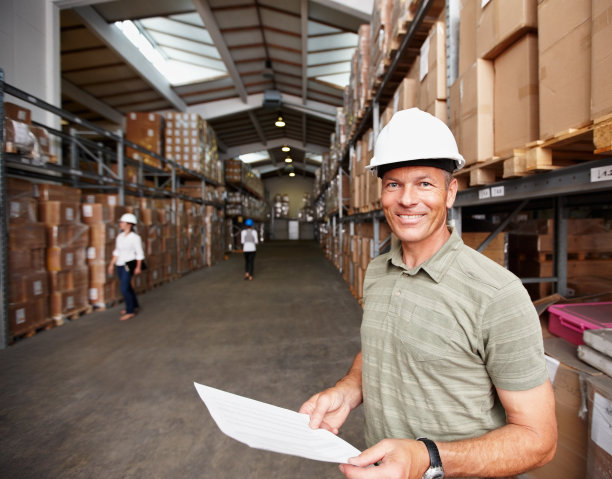 微笑的男主管和工人在仓库图片下载