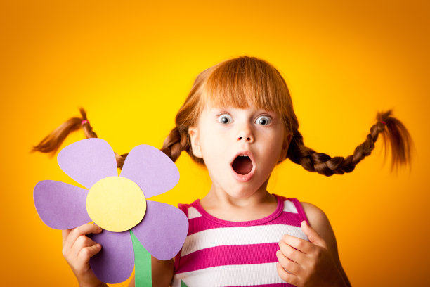 令人惊讶的红发女孩，梳着向上的辫子和超大的花图片下载