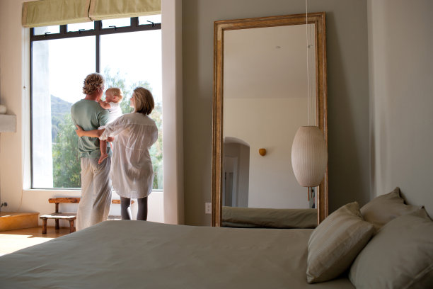 一对夫妇和一个婴儿看着窗外图片下载