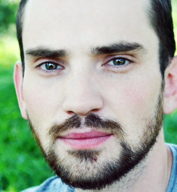 留着胡子的年轻人看上去若有所思，面带微笑图片下载