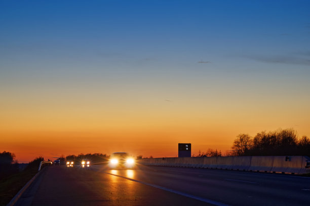 日落后，高速公路上开着耀眼的聚光灯图片下载