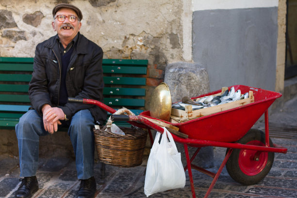 西西里岛，Cefalu:红手推车装满鱼的鱼贩子图片下载
