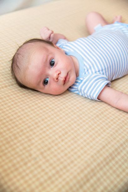 蓝色和白色的婴儿男孩躺在婴儿床图片下载