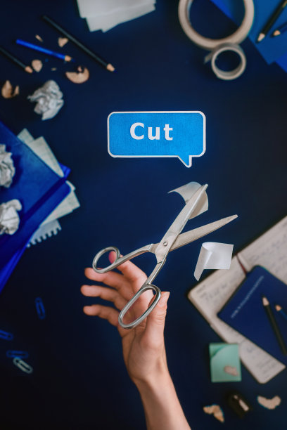 作家的工作场所:手拿剪刀在记事本和文具之间图片下载