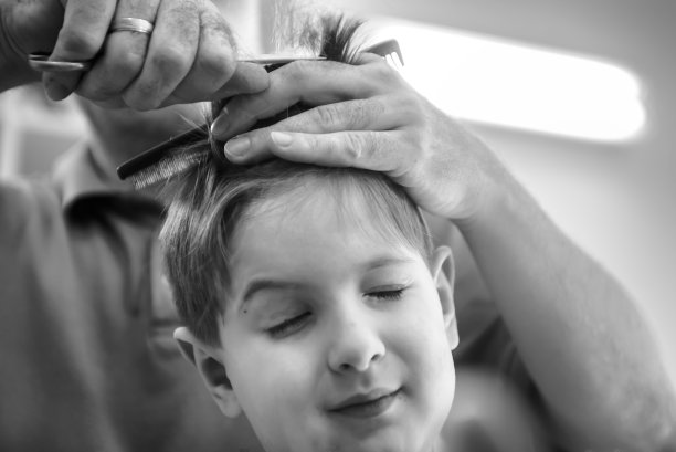 一个男孩剪了头发的特写。黑白照片图片下载