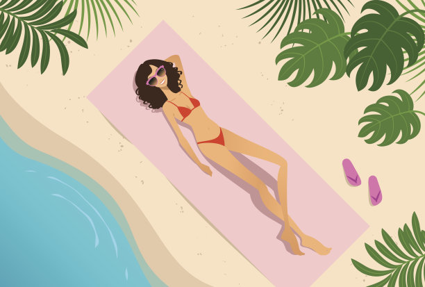 年轻女子在海滩上晒日光浴图片下载