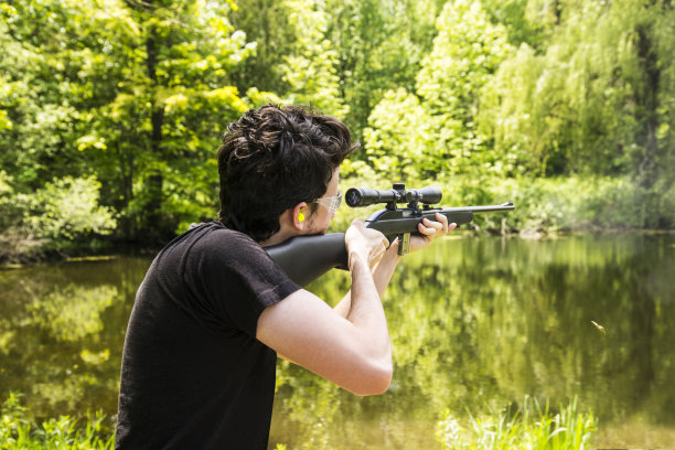 一个年轻人在乡下用22口径步枪射击图片下载
